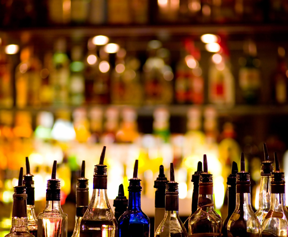 Bottles lined up along a warmly lit bar