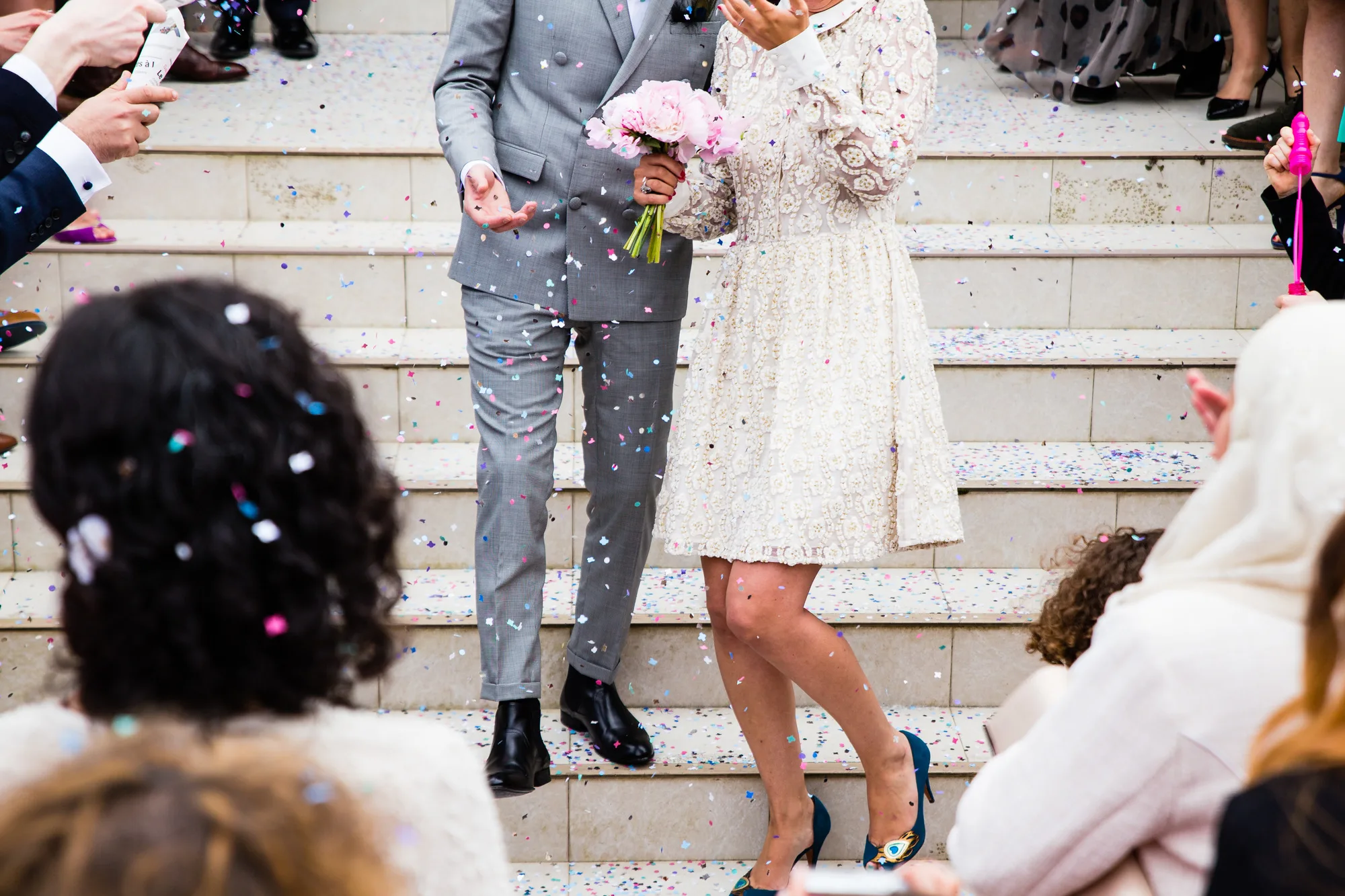 A newly married couple leaving through a shower of confetti